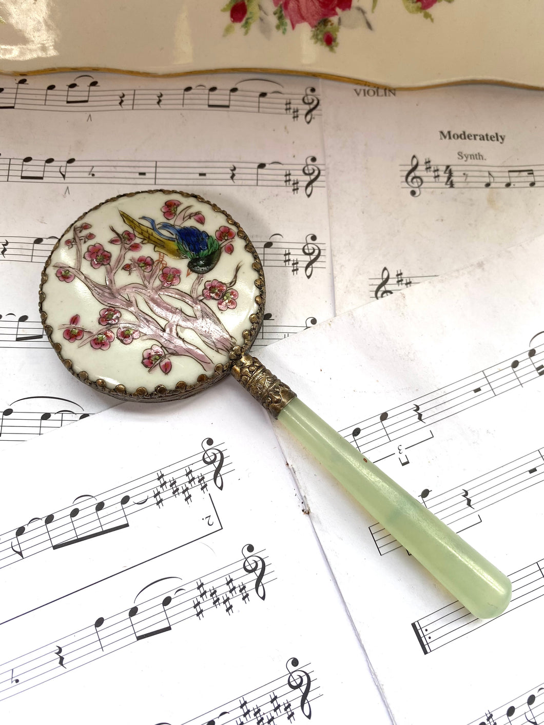 Vintage hand mirror with enamelled back